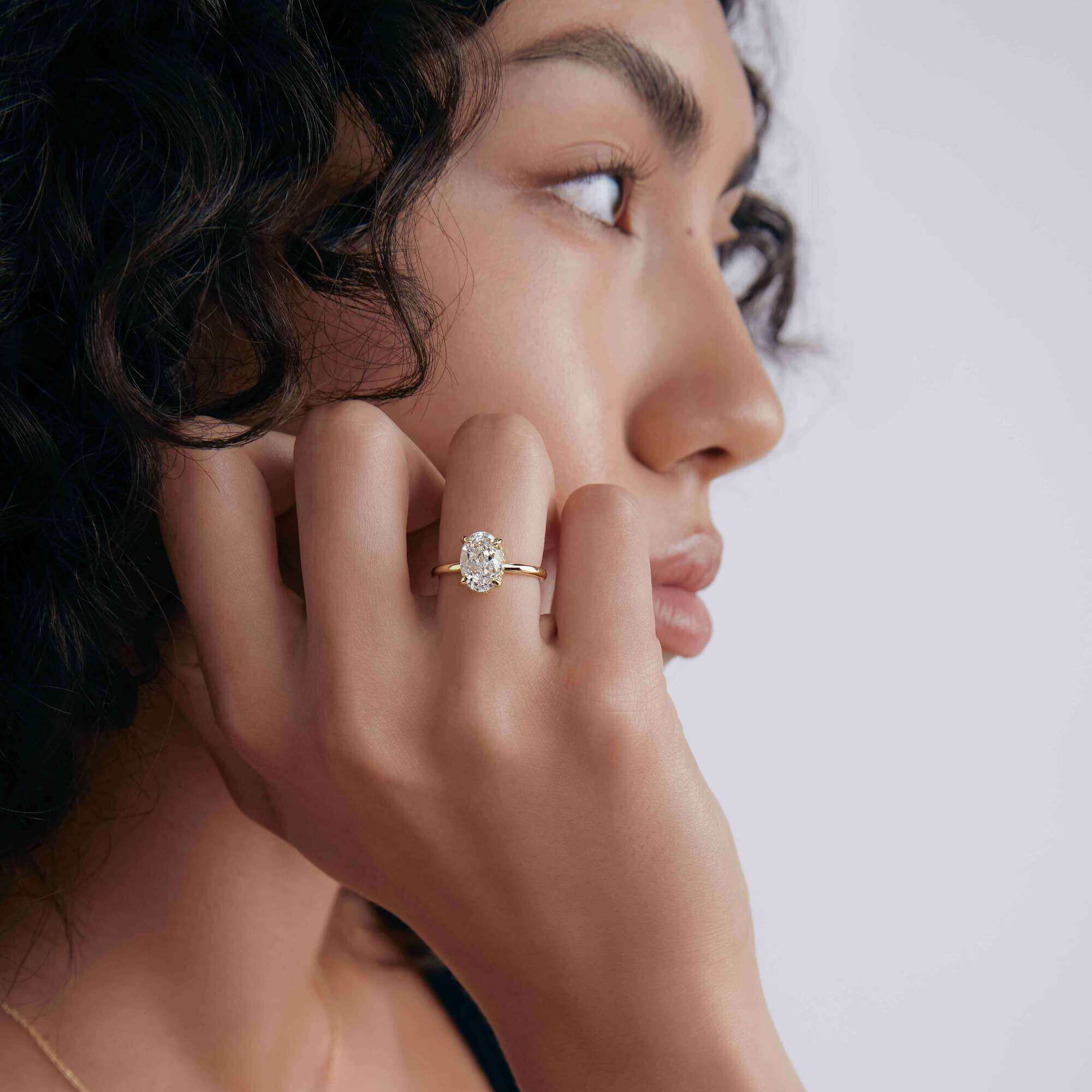 2 ct oval-cut moissanite solitaire ring worn on a finger.