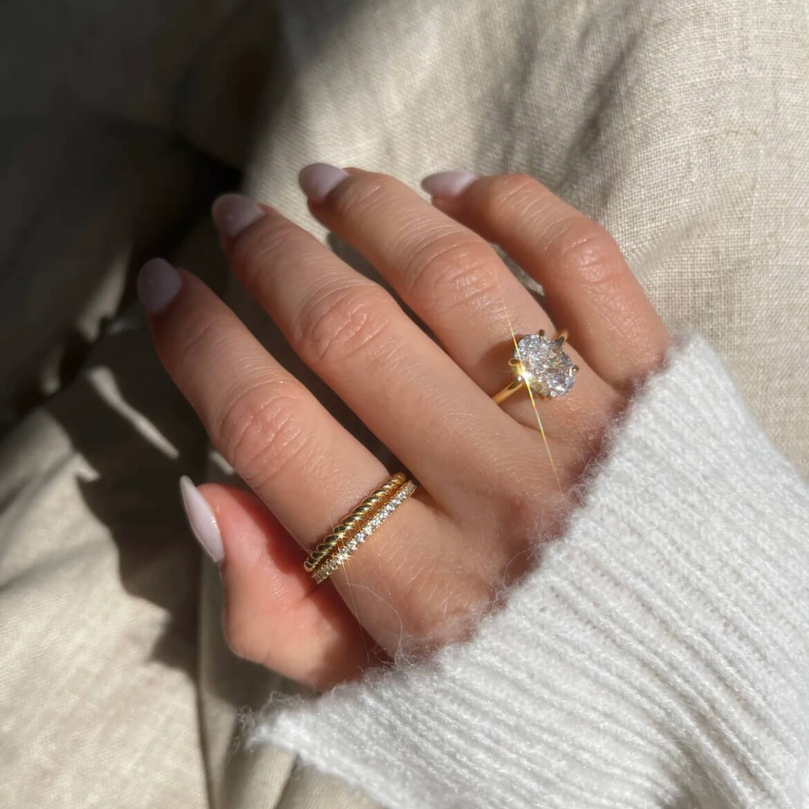 2 ct oval-cut moissanite solitaire ring worn on a finger.