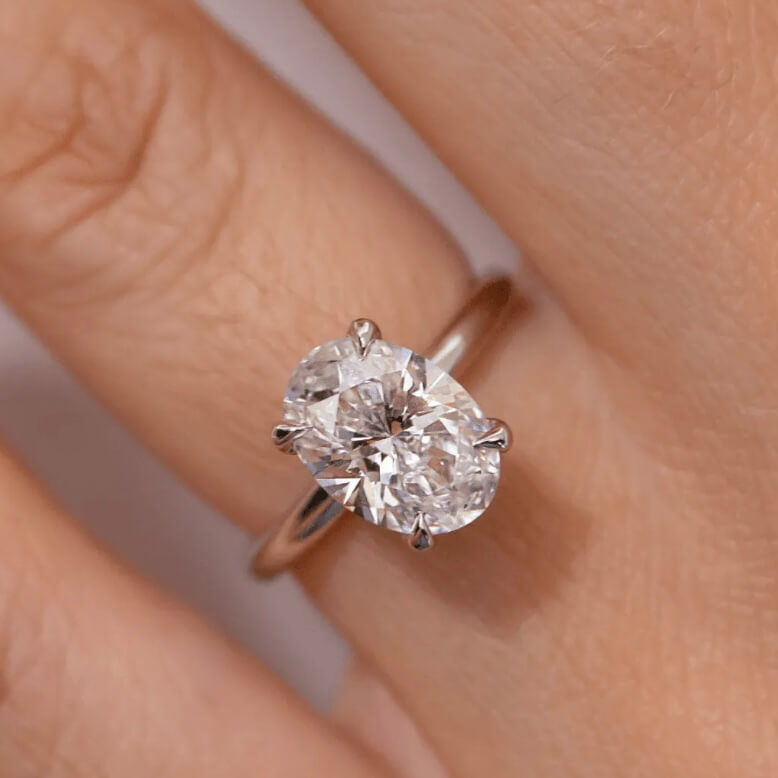 2 ct oval-cut moissanite solitaire ring worn on a finger.