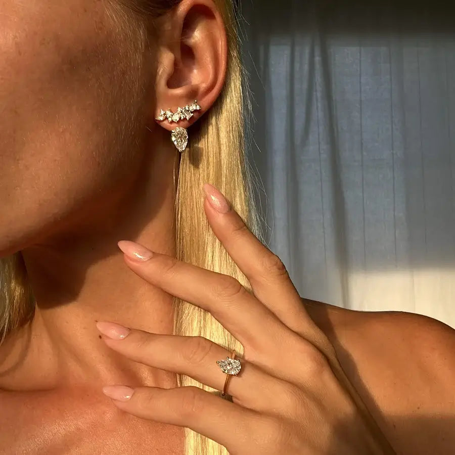 2 ct pear-cut moissanite solitaire ring worn on a finger.