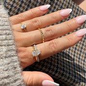 2 ct pear-cut moissanite solitaire ring worn on a finger.