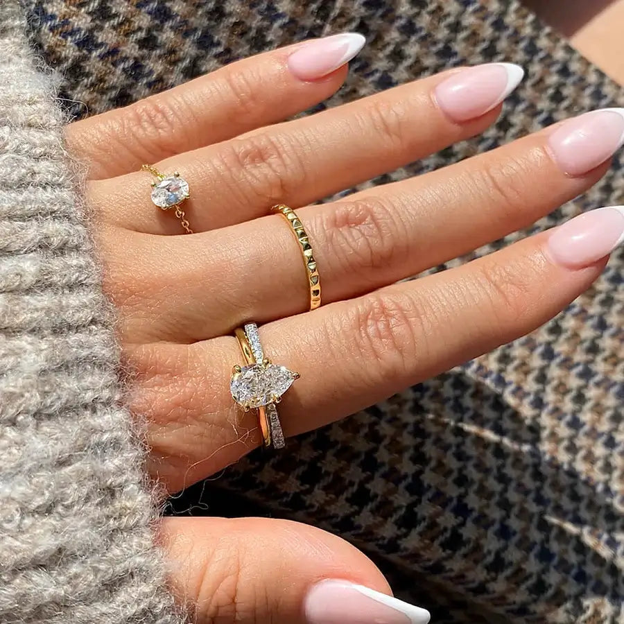 2 ct pear-cut moissanite solitaire ring worn on a finger.