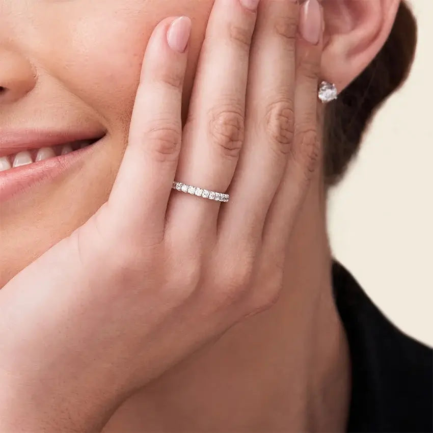 2 mm moissanite eternity ring worn on a finger.