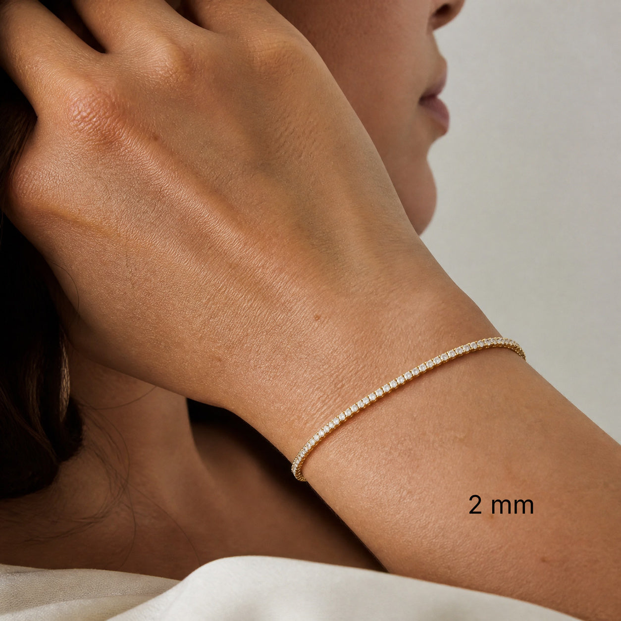 2 mm yellow gold vermeil moissanite tennis bracelet worn on wrist.