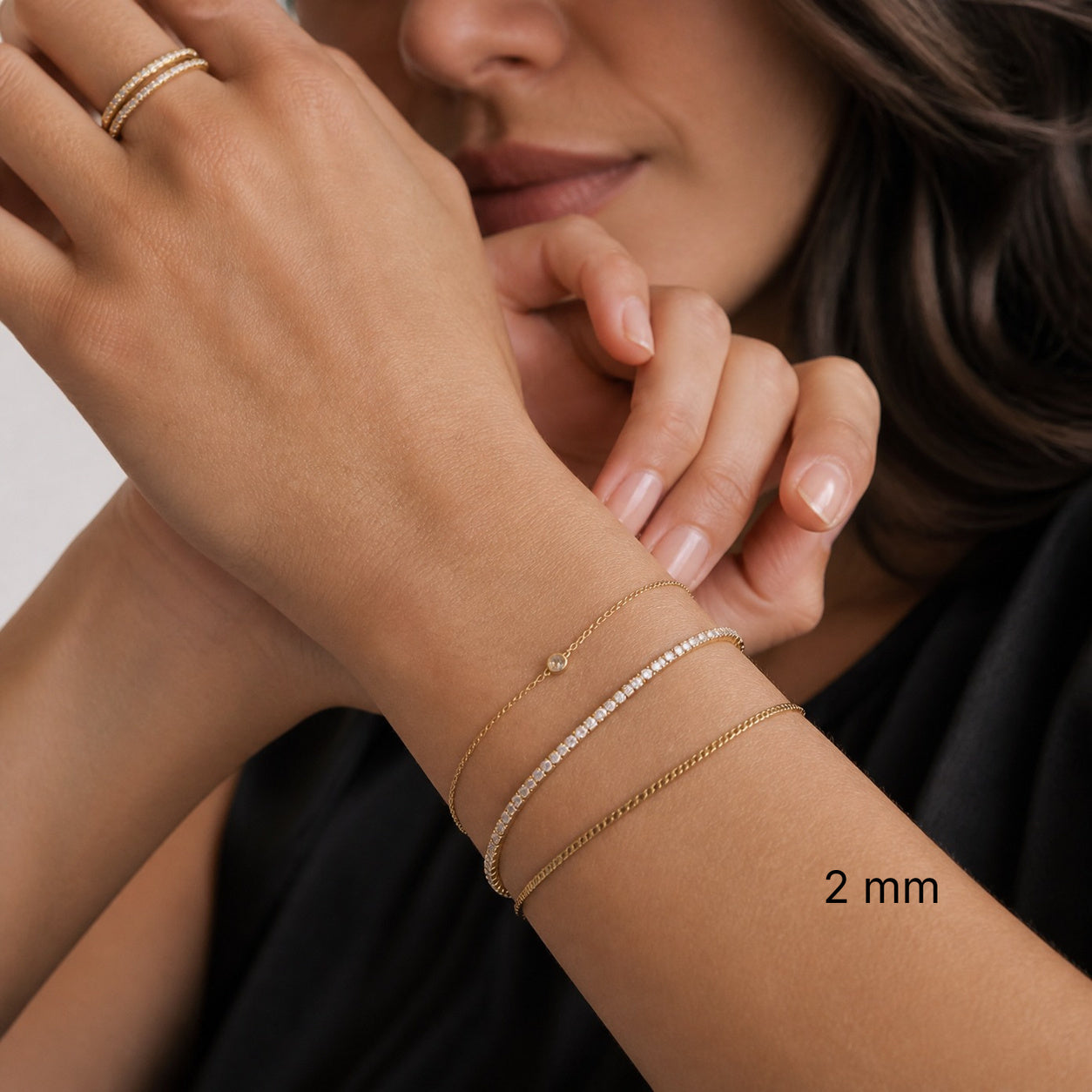2 mm yellow gold vermeil moissanite tennis bracelet styled with gold bracelets.