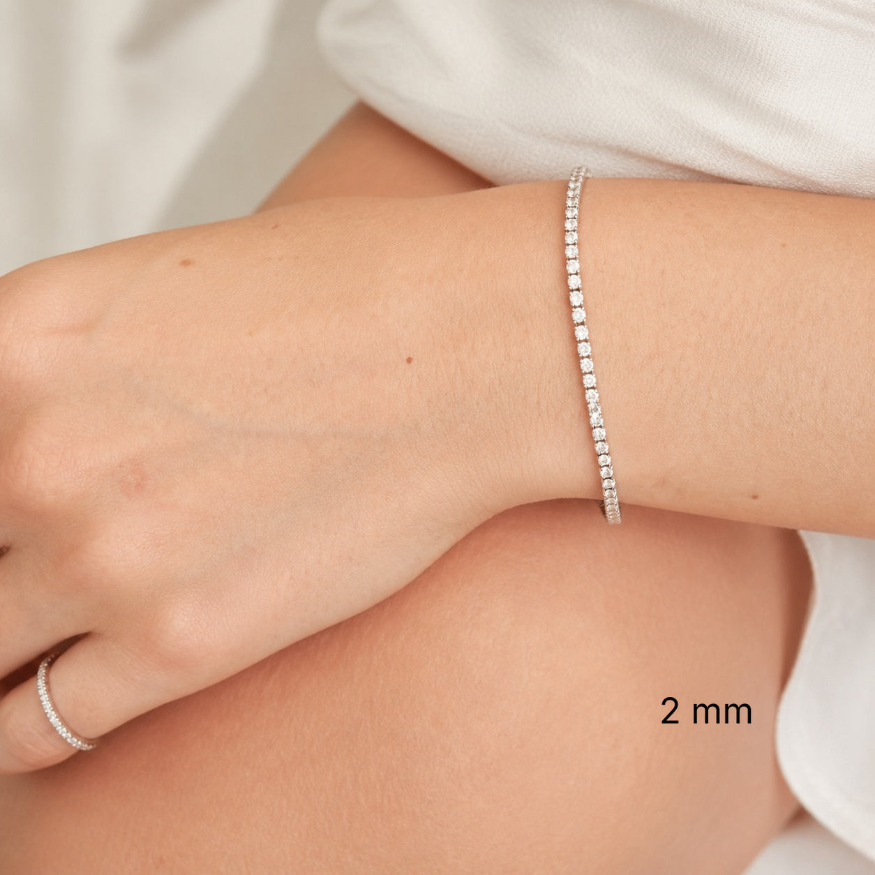 2 mm white gold vermeil moissanite tennis bracelet worn on wrist.