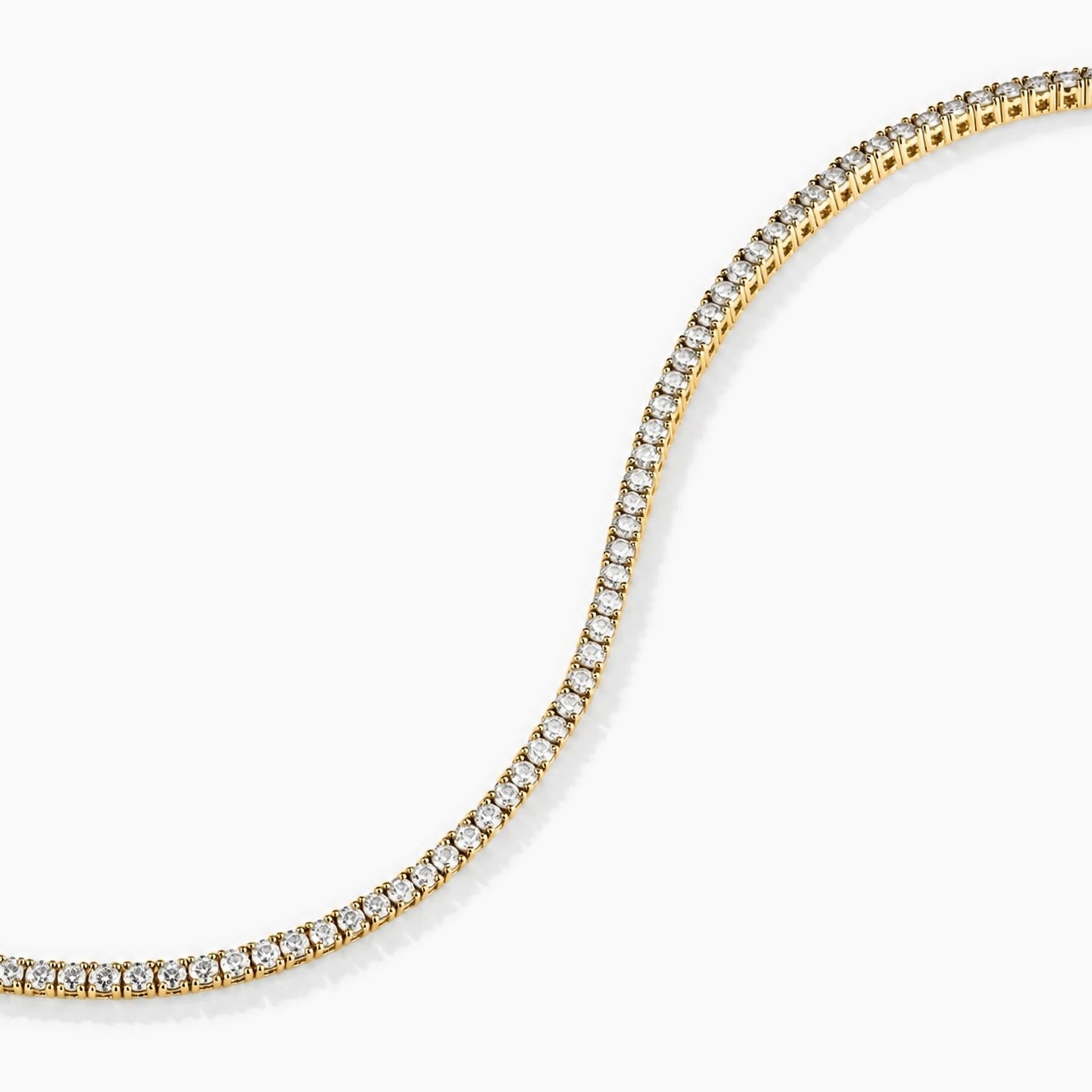 2 mm moissanite tennis bracelet in yellow gold vermeil, curved stone row detail.