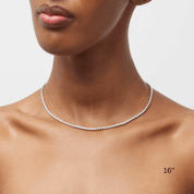 2 mm moissanite tennis necklace worn at the neckline.
