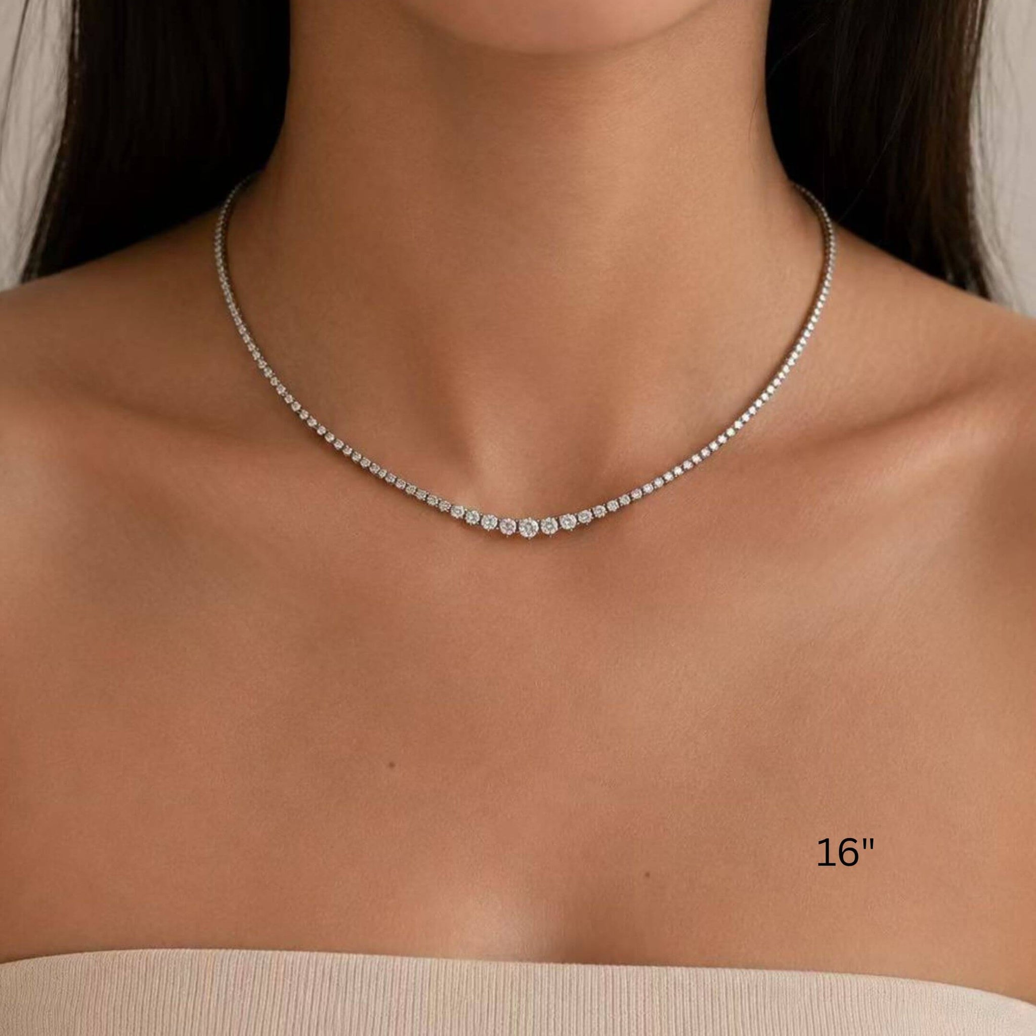 2–4 mm graduated moissanite tennis necklace worn at the neckline.