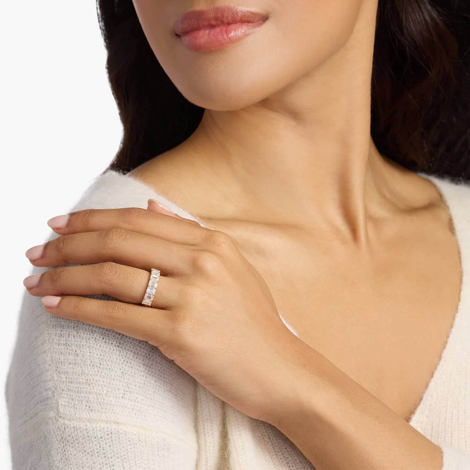 3 ct emerald-cut moissanite half eternity ring worn on a finger.