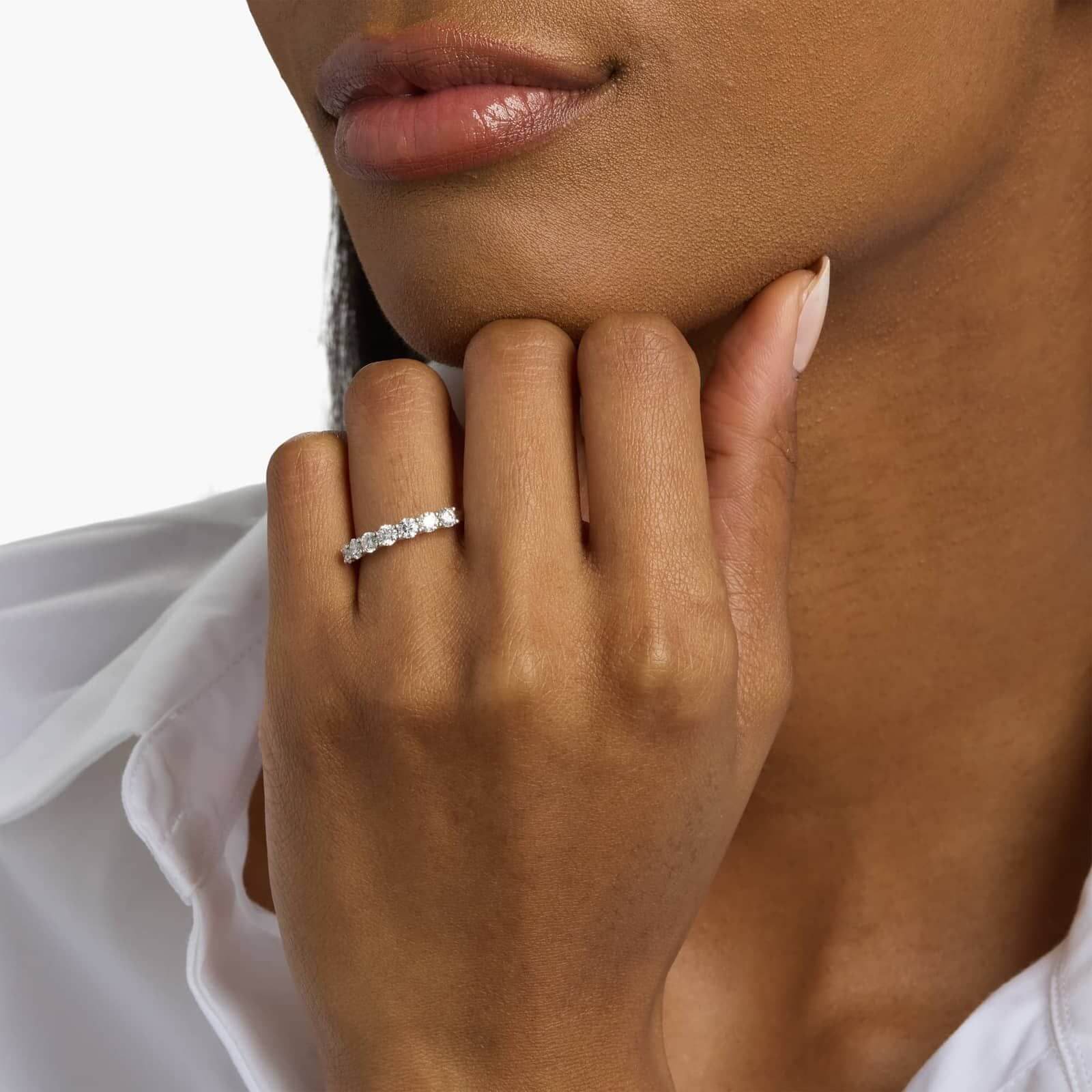 3 mm moissanite half eternity ring worn on a finger.