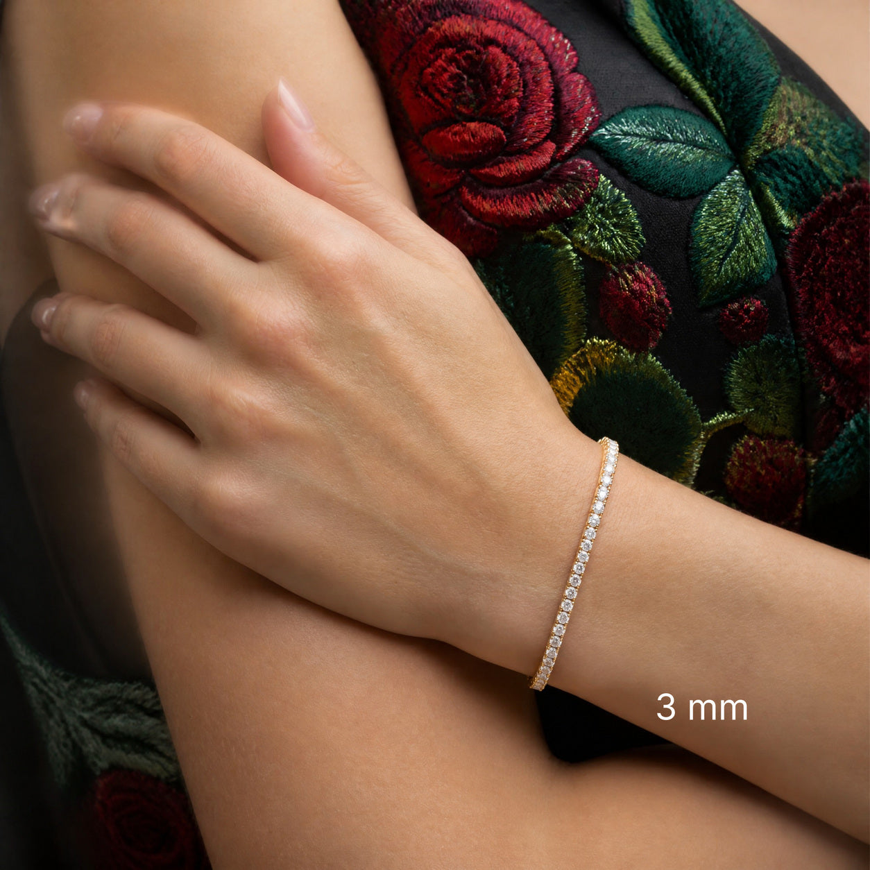 3 mm yellow gold vermeil moissanite tennis bracelet worn on wrist with embroidered floral outfit, white 3 mm label.