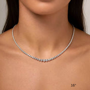 3–4.5 mm graduated moissanite tennis necklace worn at the neckline.
