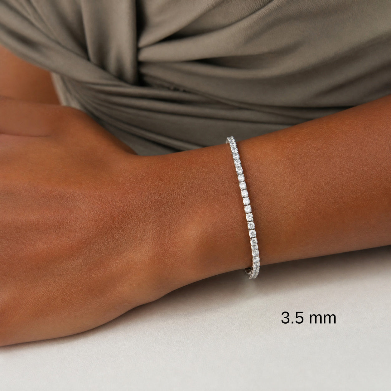 3.5 mm white gold vermeil moissanite tennis bracelet on wrist, black size label.