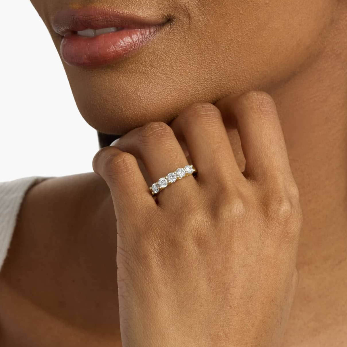 4 mm moissanite half eternity ring worn on a finger.