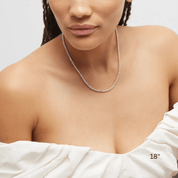 4 mm moissanite tennis necklace worn at the neckline.
