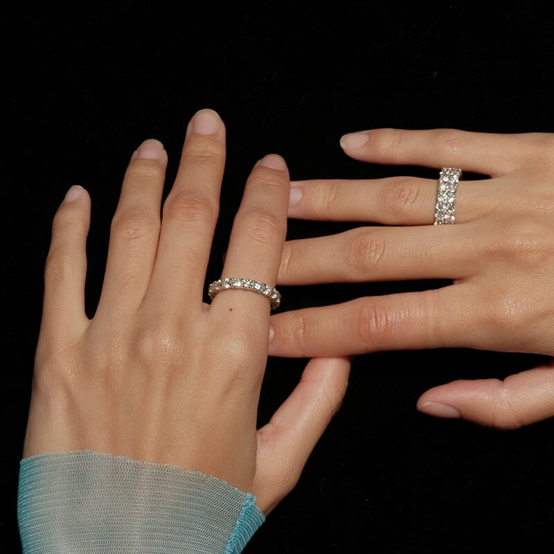 6 mm wide moissanite double-row eternity ring worn on a finger.