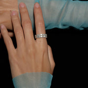 6 mm wide moissanite double-row eternity ring worn on a finger.