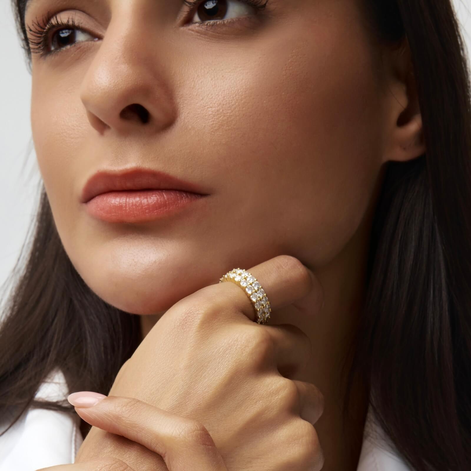 6 mm wide moissanite double-row eternity ring worn on a finger.