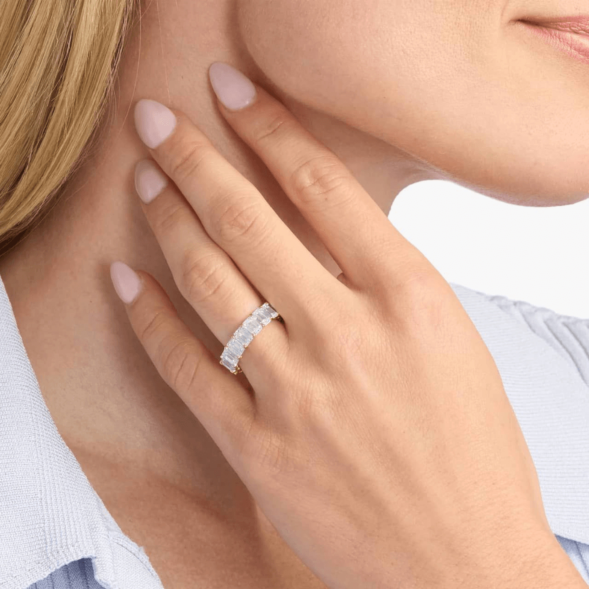 9 ct emerald-cut moissanite eternity ring worn on a finger.