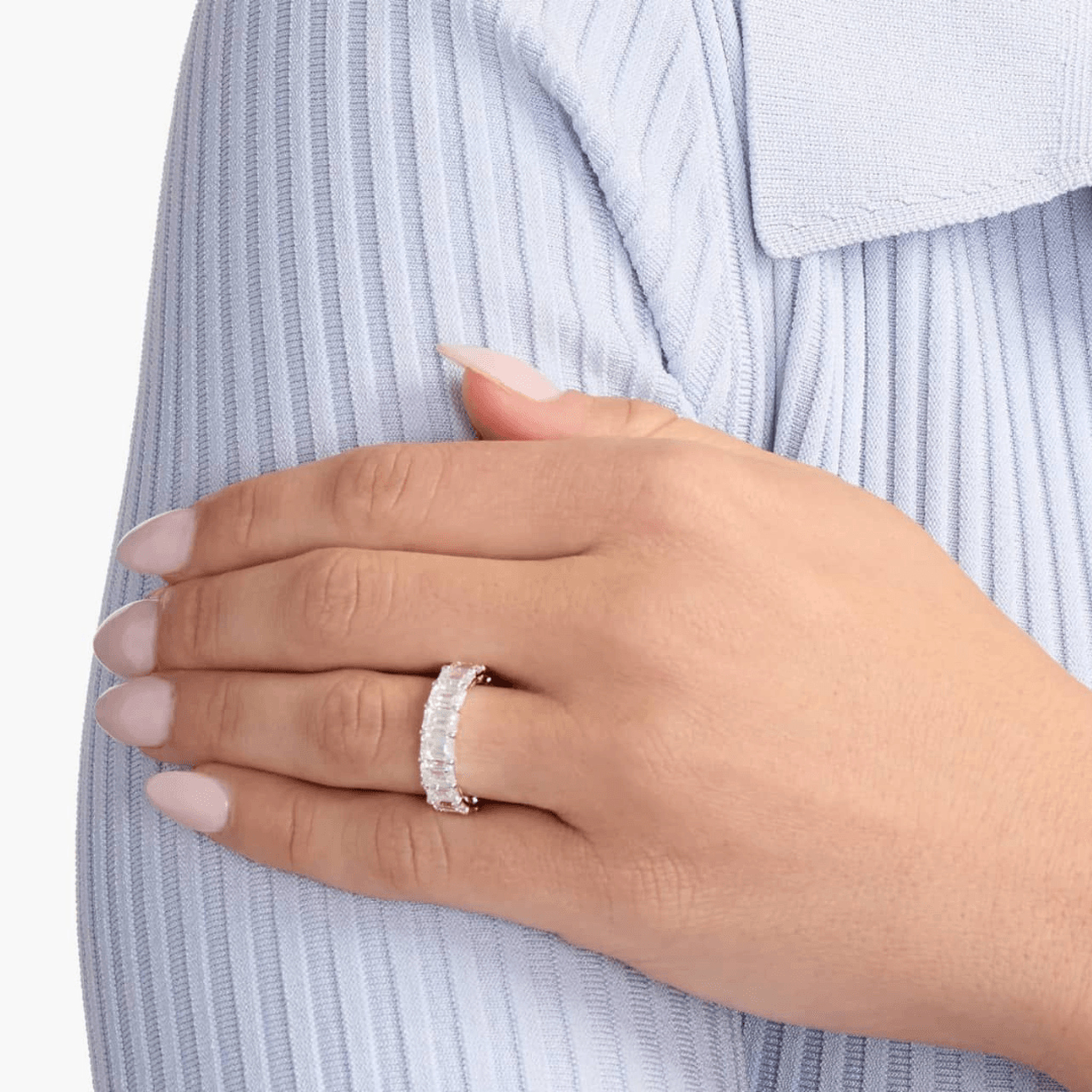 9 ct emerald-cut moissanite eternity ring worn on a finger.