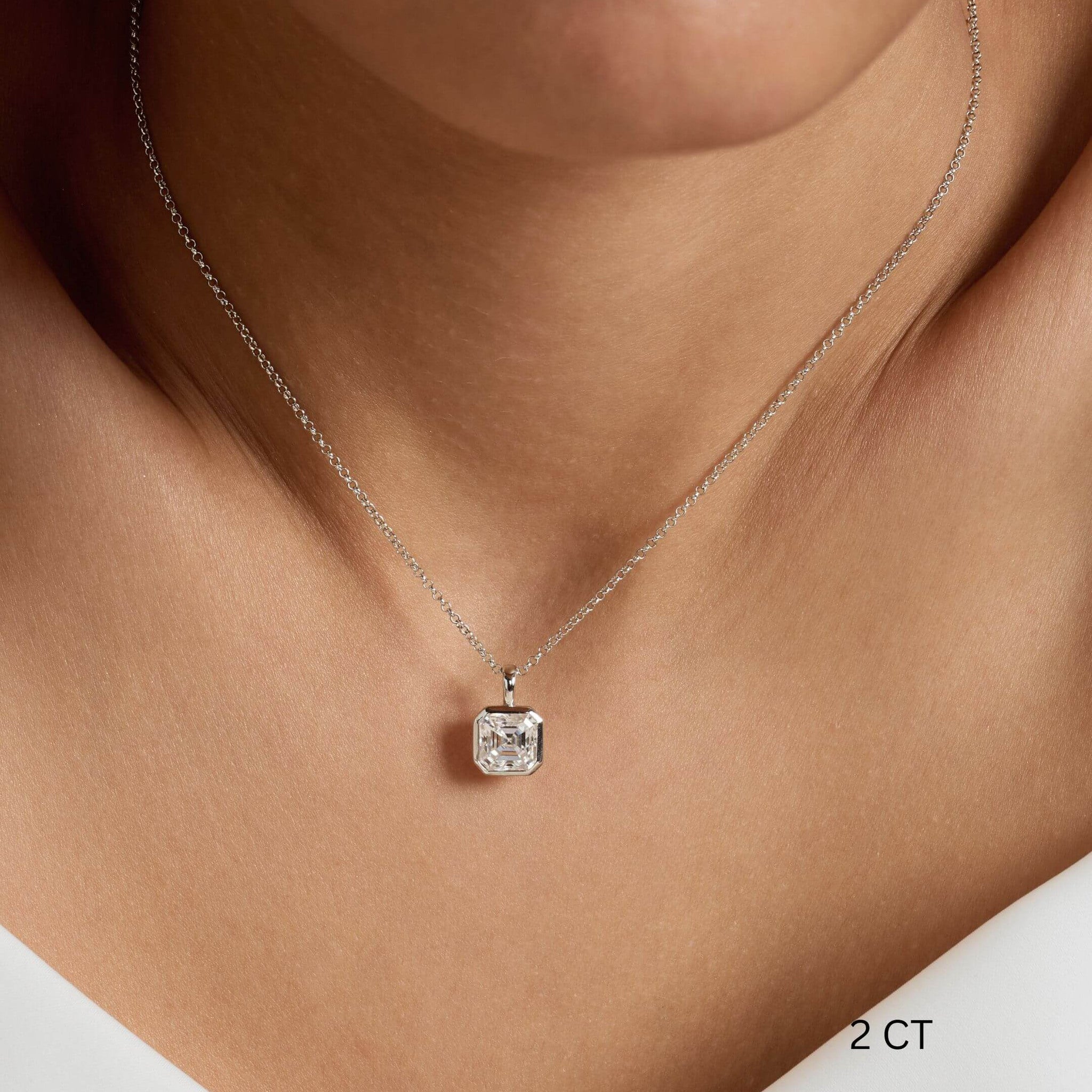 Asscher-cut moissanite bezel pendant necklace worn at the neckline.