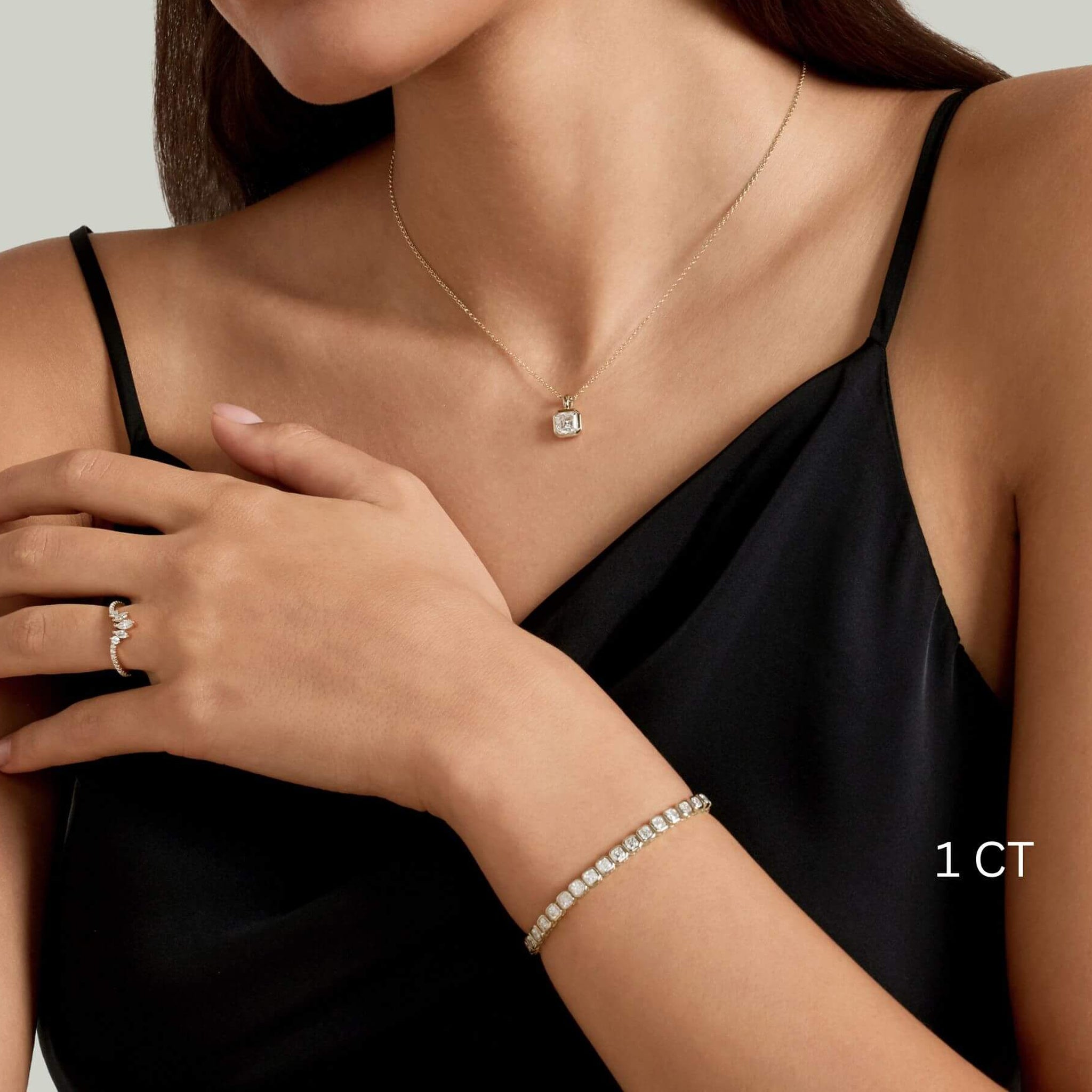 Asscher-cut moissanite bezel pendant necklace worn at the neckline.