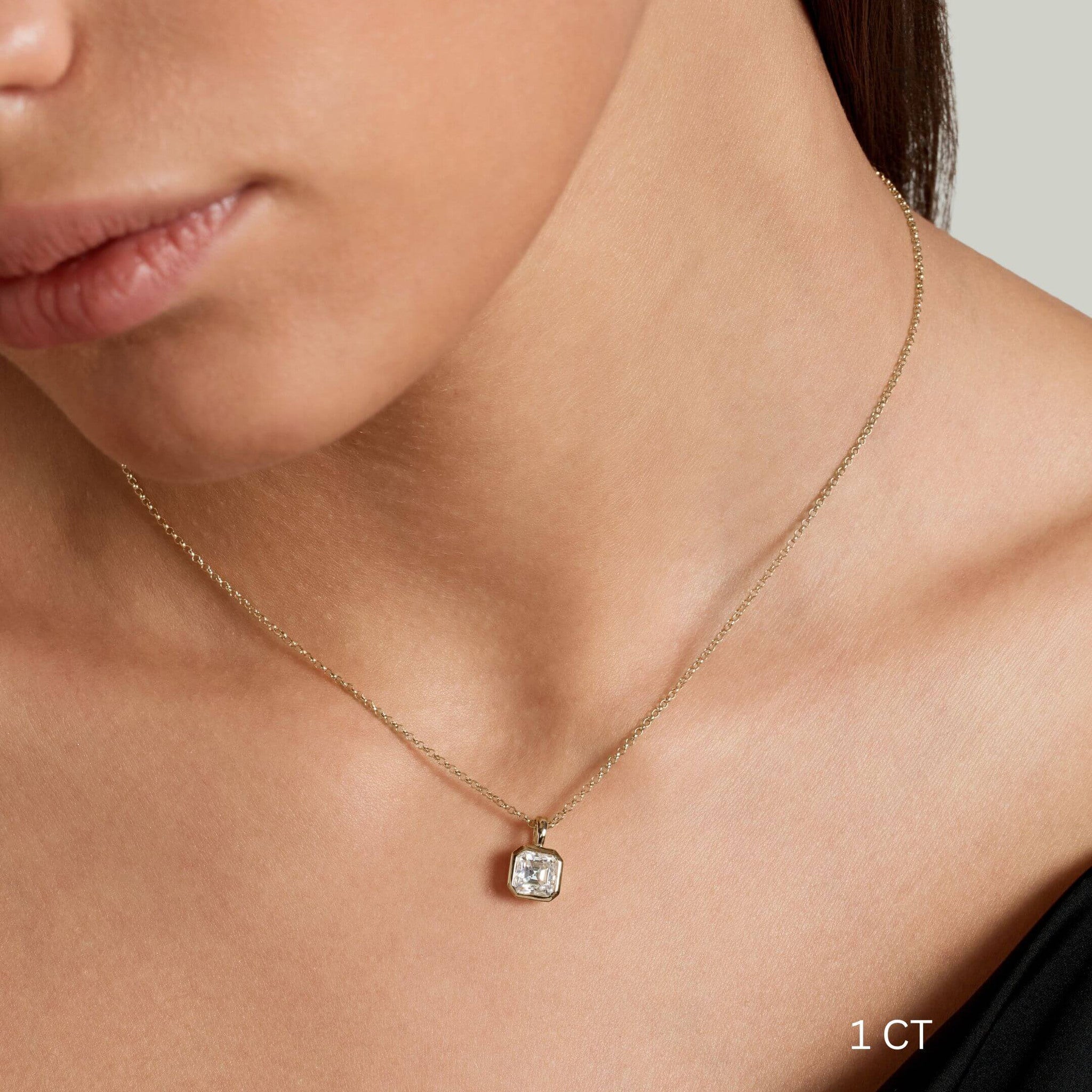 Asscher-cut moissanite bezel pendant necklace worn at the neckline.