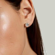 Asscher-cut moissanite bezel stud earrings worn on the ear with a 2 ct size label.