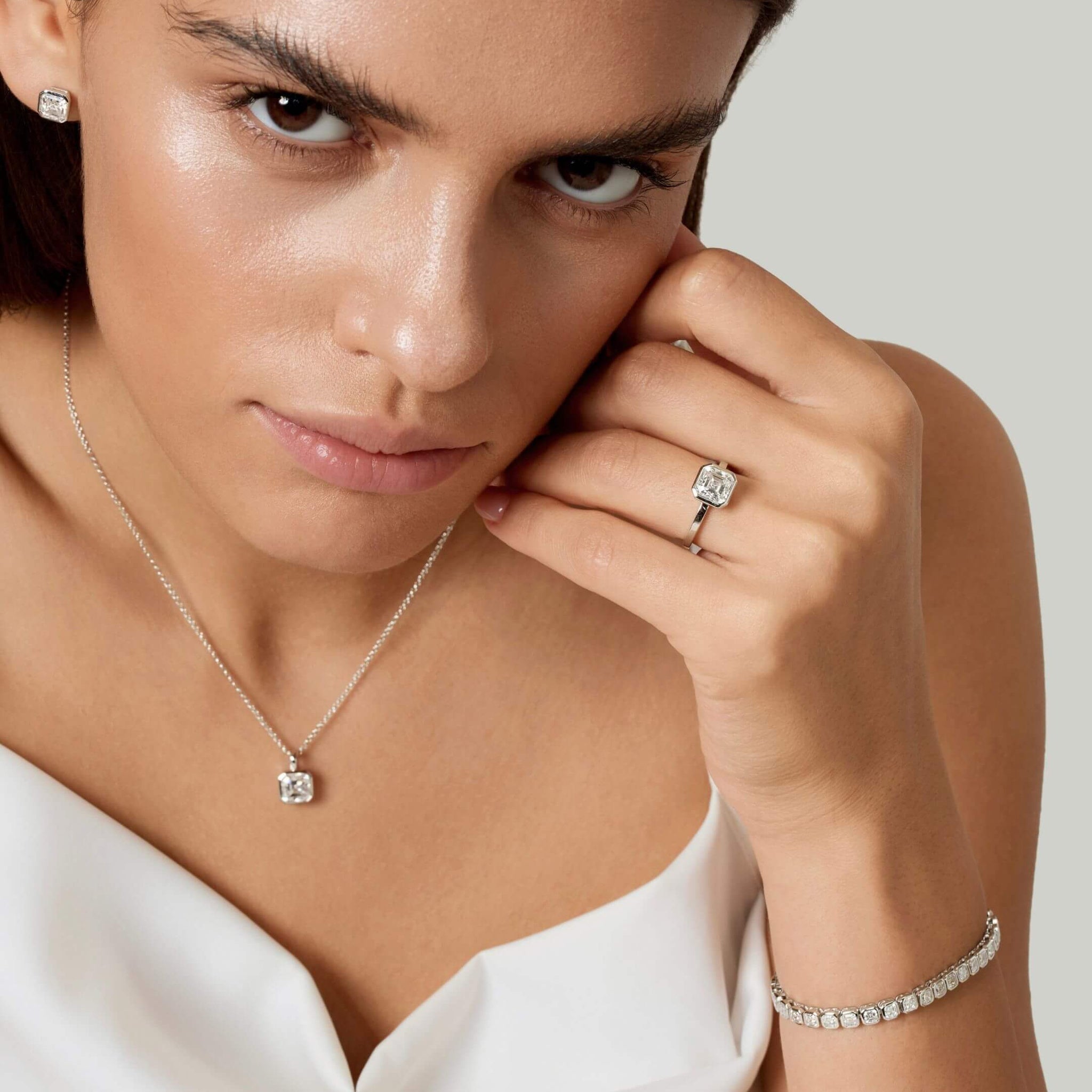 Asscher-cut moissanite bezel tennis bracelet worn on the wrist.