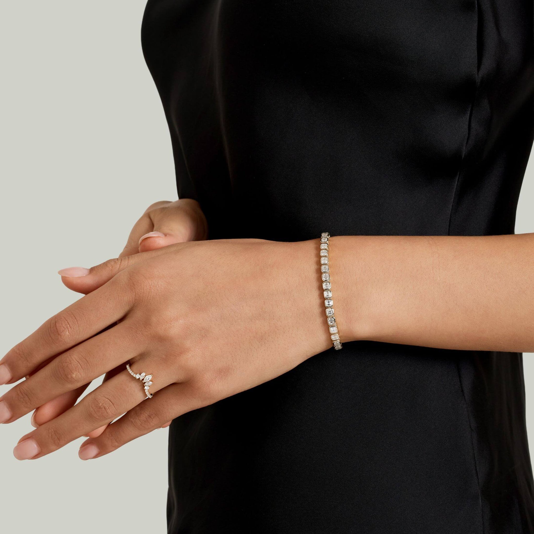 Asscher-cut moissanite bezel tennis bracelet worn on the wrist.