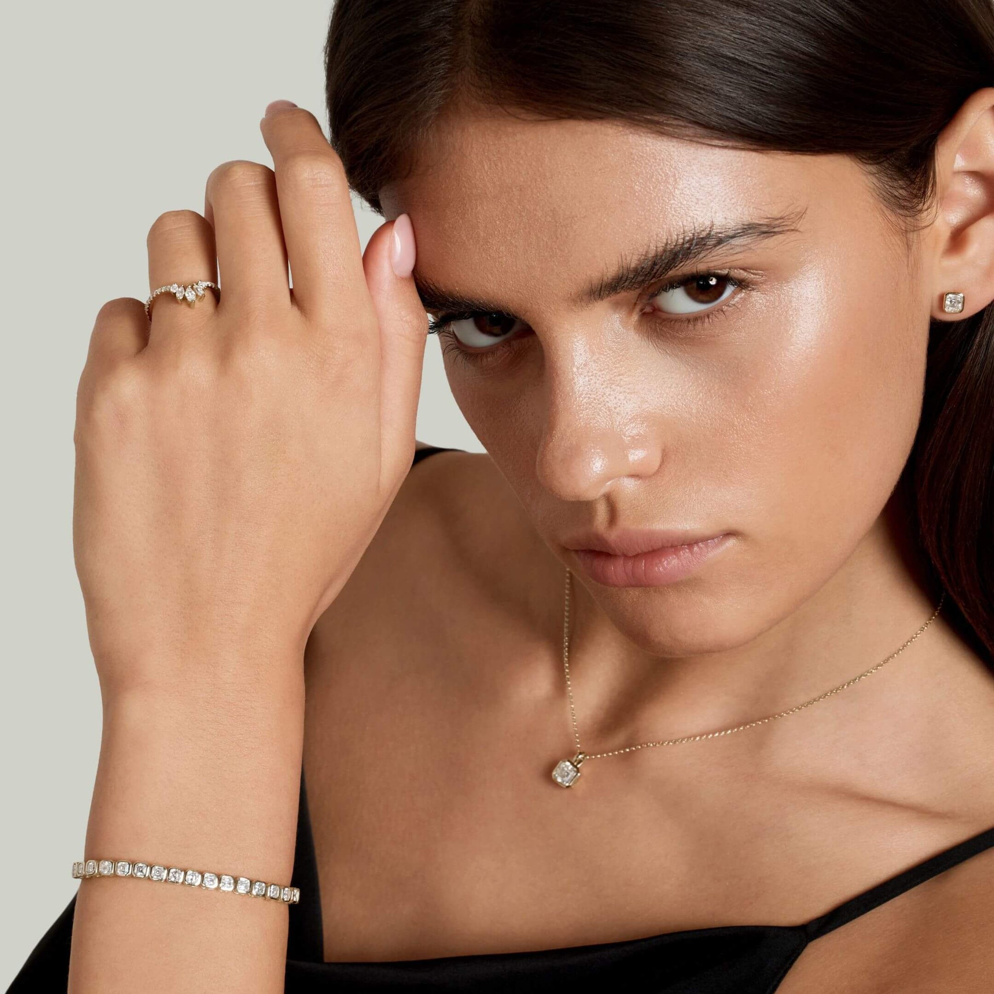 Asscher-cut moissanite bezel tennis bracelet worn on the wrist.
