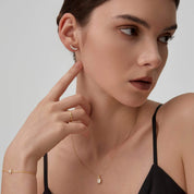 Curved moissanite stud earrings worn on the ear.