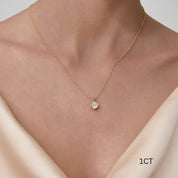 Cushion-cut moissanite bezel pendant necklace worn at the neckline.