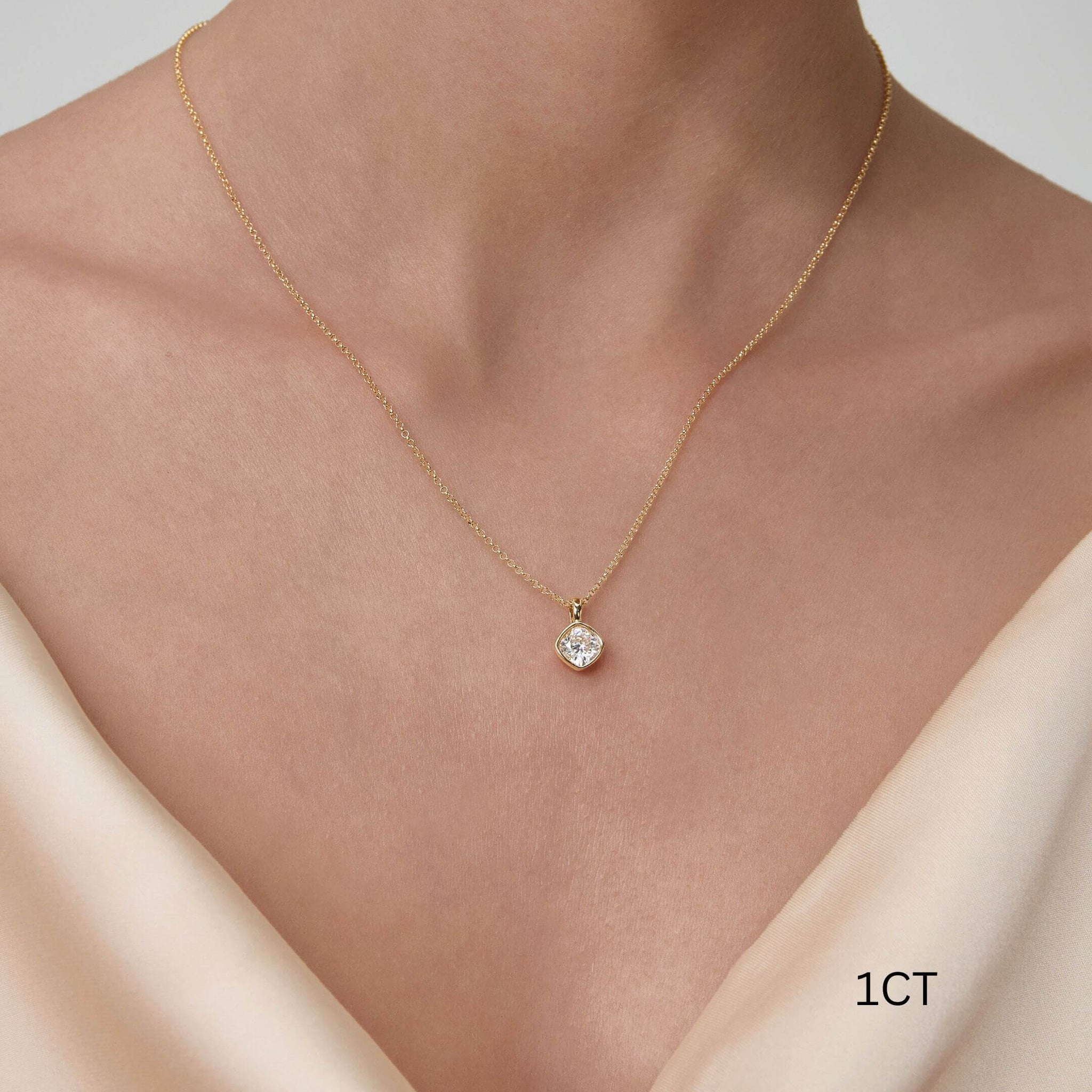 Cushion-cut moissanite bezel pendant necklace worn at the neckline.
