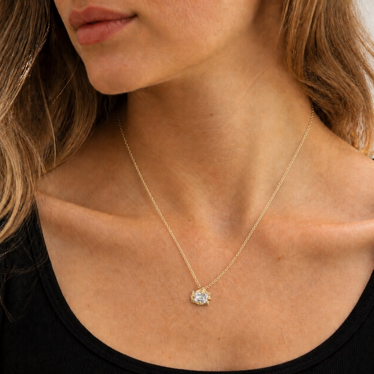 2 ct East-West Emerald-Cut Moissanite Bezel-Prong Pendant Necklace in 18k yellow gold vermeil, worn on a model.
