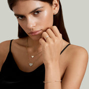 East-west marquise-cut moissanite solitaire ring with pavé band worn on a finger.
