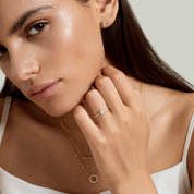 East-west oval-cut moissanite solitaire ring with pavé band worn on a finger.
