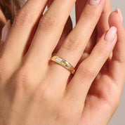 Emerald-cut moissanite bezel dome ring worn on a finger.