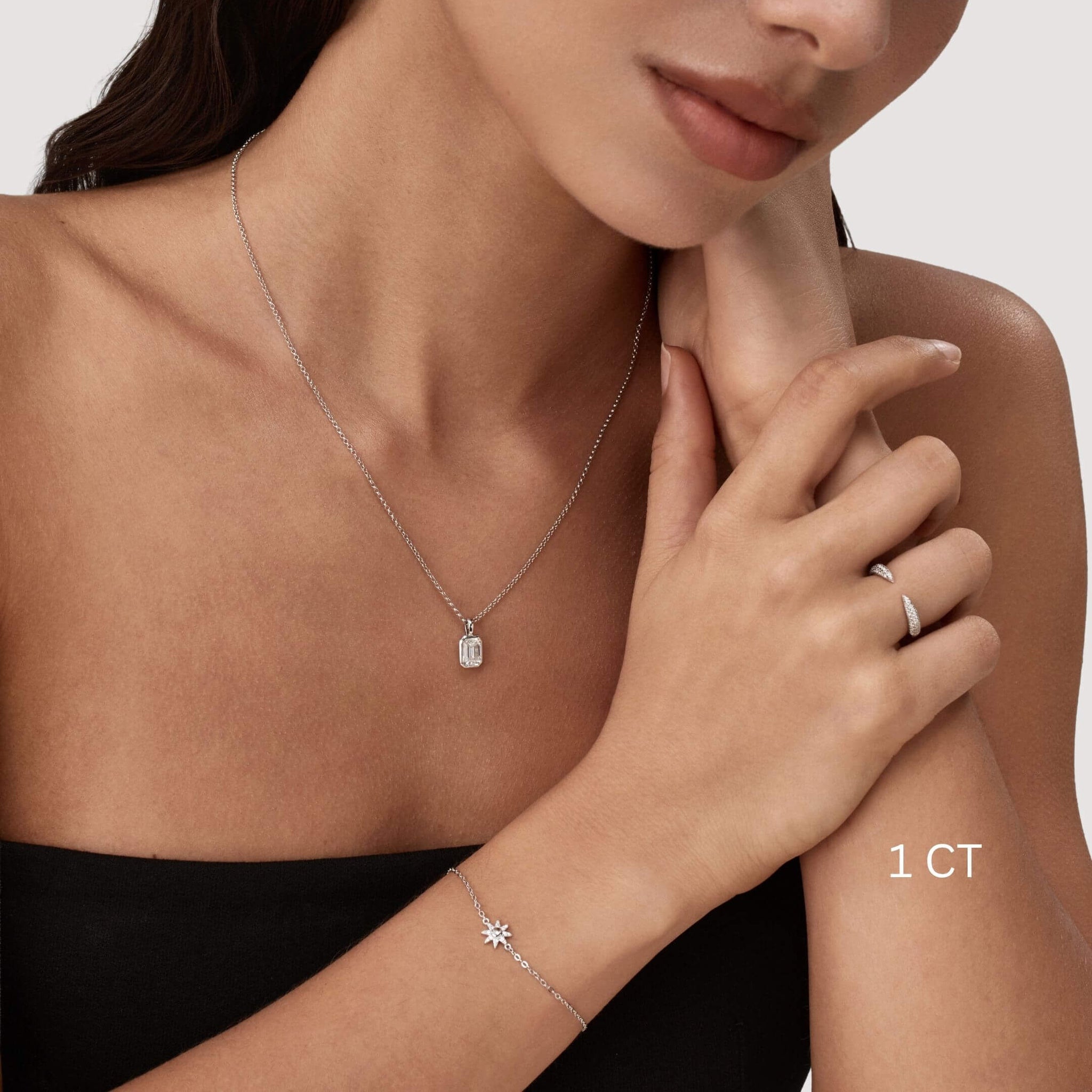 Emerald-cut moissanite bezel pendant necklace worn at the neckline.