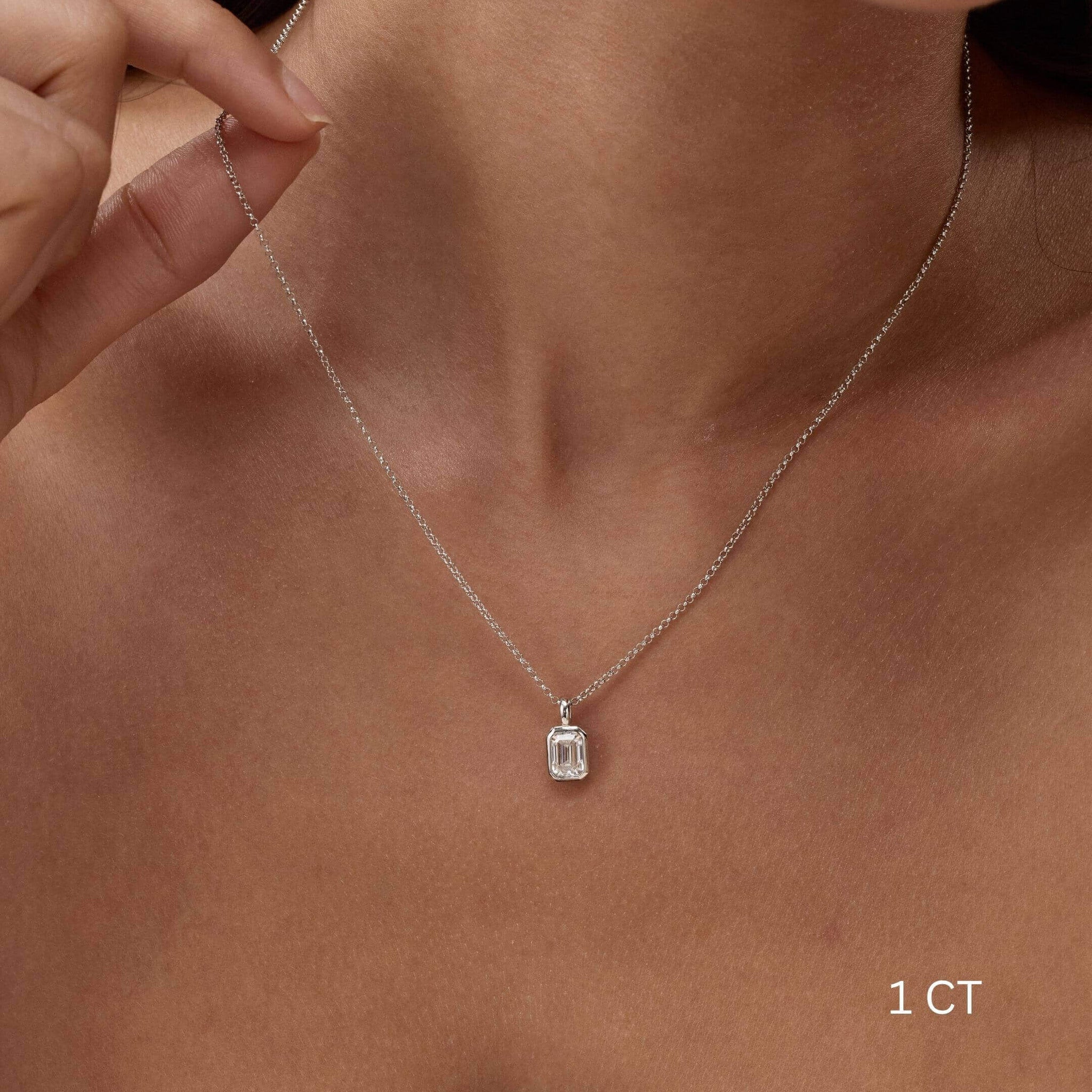 Emerald-cut moissanite bezel pendant necklace worn at the neckline.