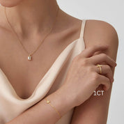 Emerald-cut moissanite bezel pendant necklace worn at the neckline.