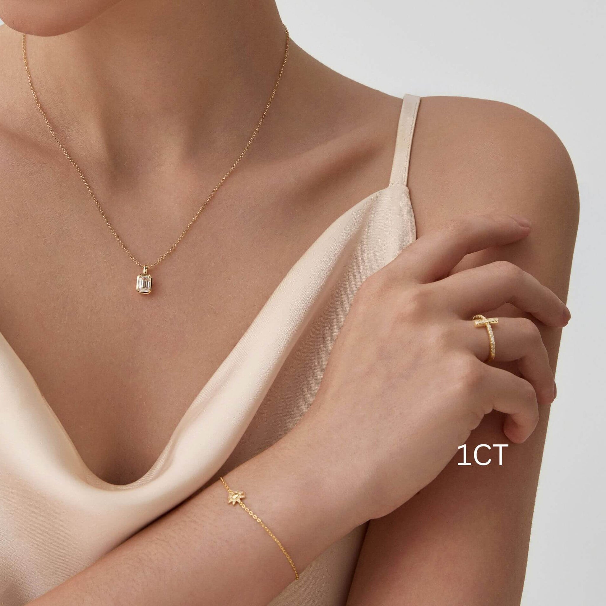 Emerald-cut moissanite bezel pendant necklace worn at the neckline.