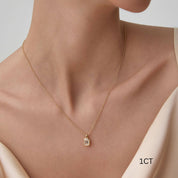Emerald-cut moissanite bezel pendant necklace worn at the neckline.