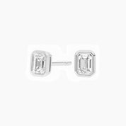 Emerald-cut moissanite bezel stud earrings in white gold vermeil, front and side views.