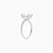 Emerald-cut moissanite hidden halo ring with pavé band in white gold vermeil, side view.