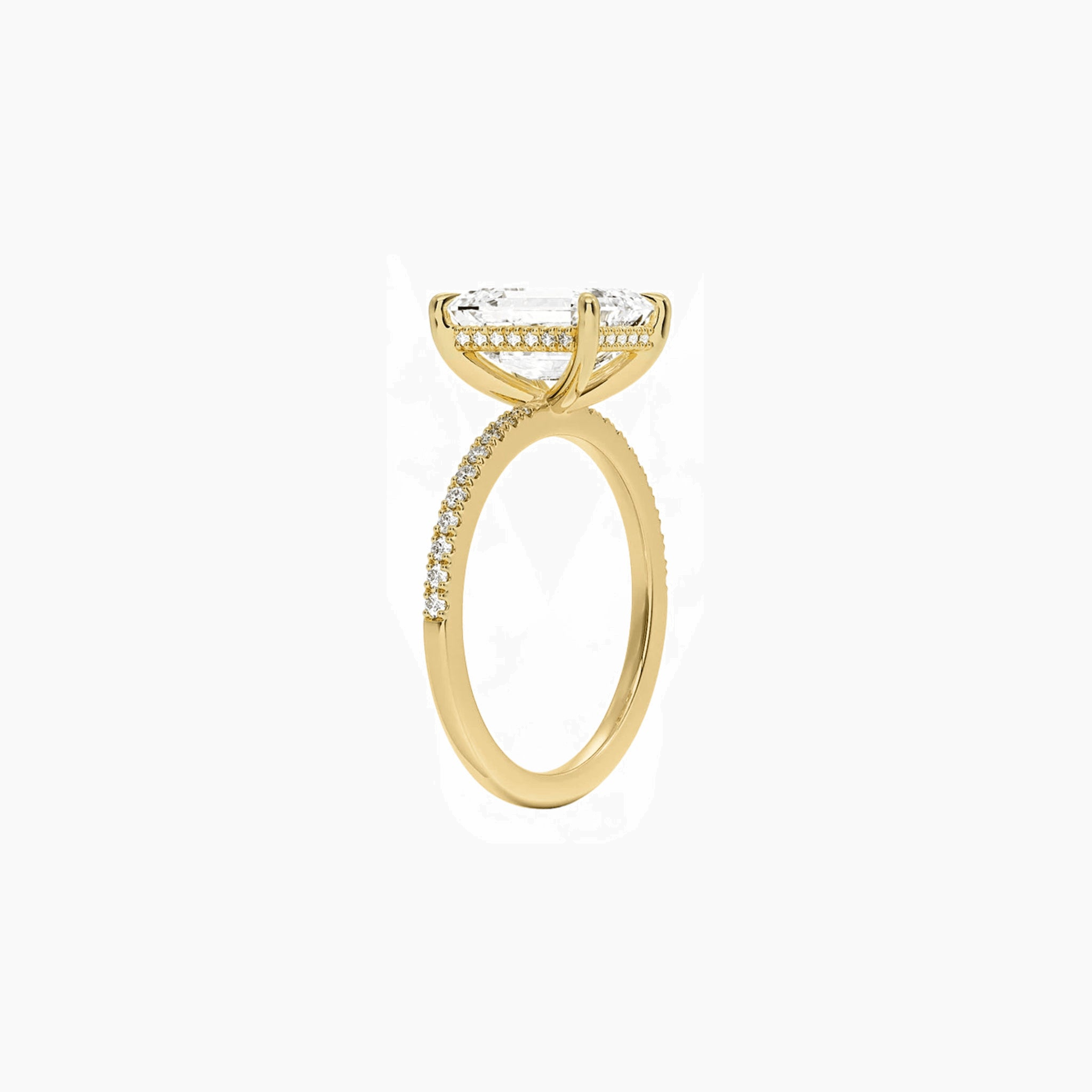 Emerald-cut moissanite hidden halo ring with pavé band in yellow gold vermeil, side view.