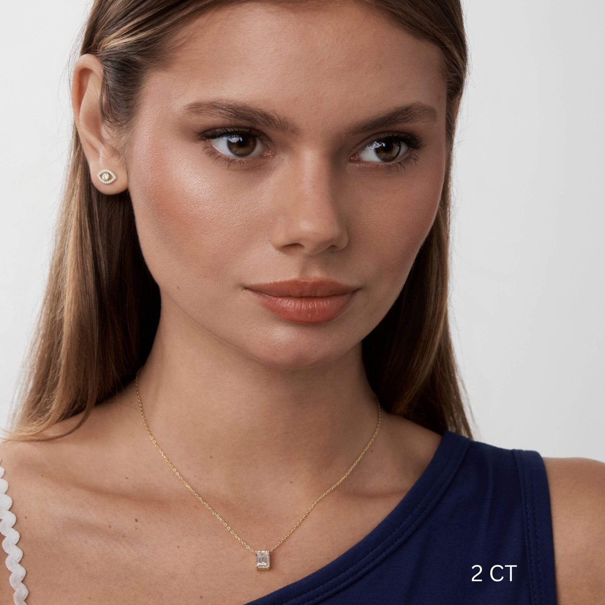 Emerald-cut moissanite pendant necklace worn at the neckline.