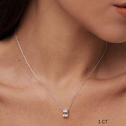 Emerald-cut moissanite pendant necklace worn at the neckline.