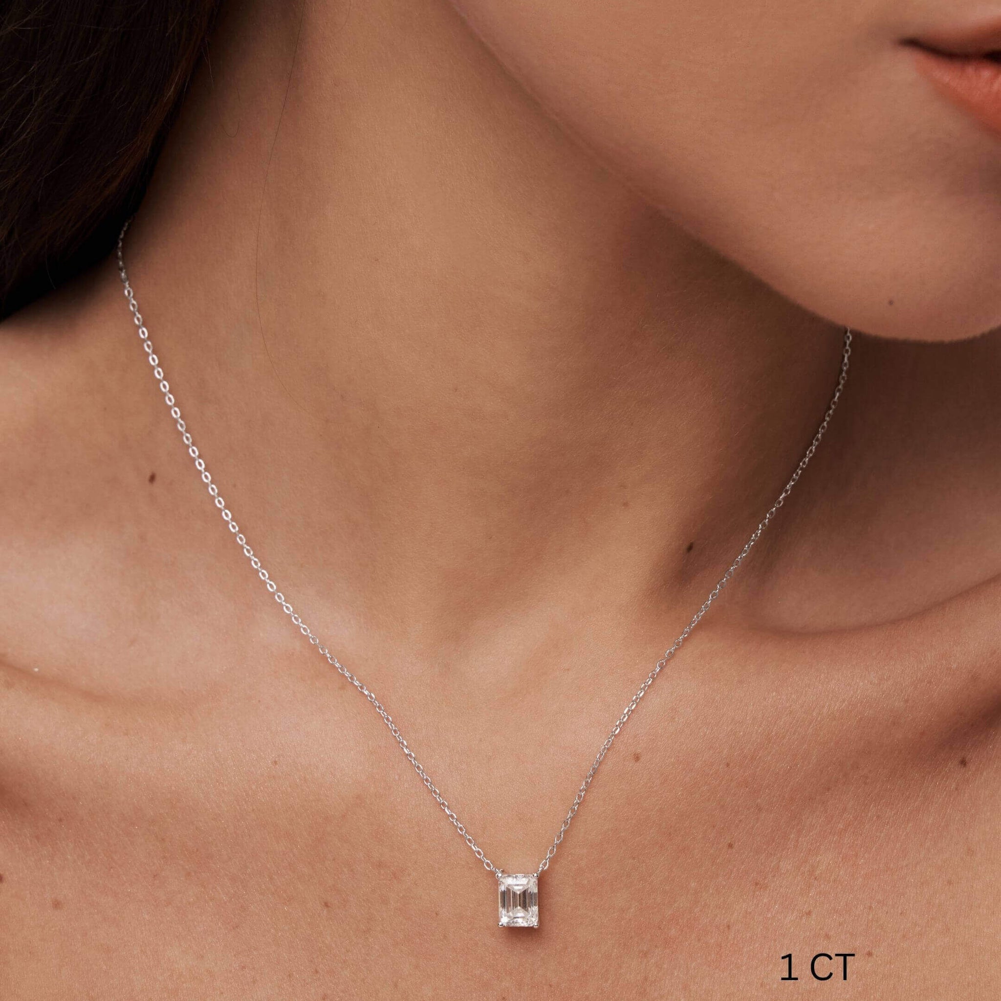 Emerald-cut moissanite pendant necklace worn at the neckline.